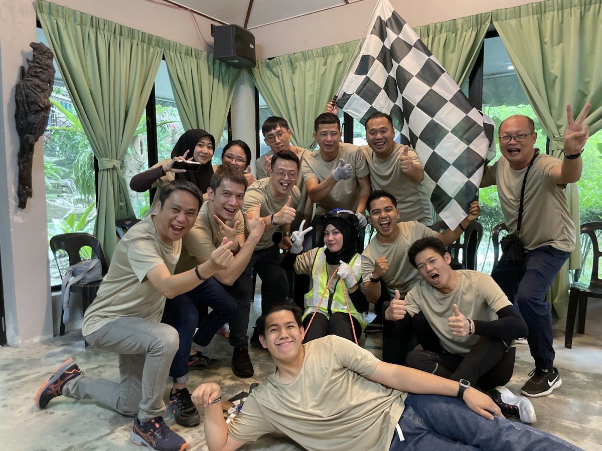 Team posing with a checkered flag after a team building challenge
