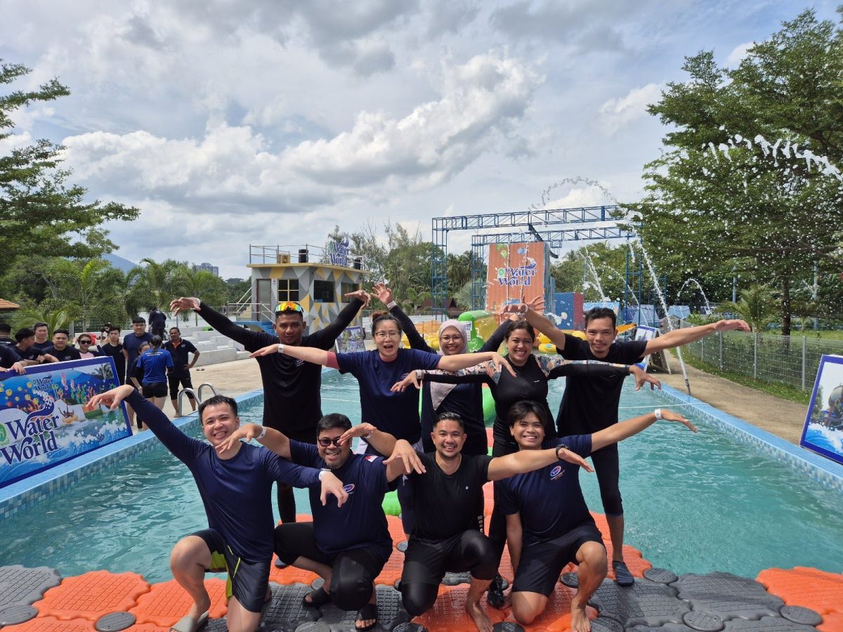 Team posing on a floating platform at a Water World team building event